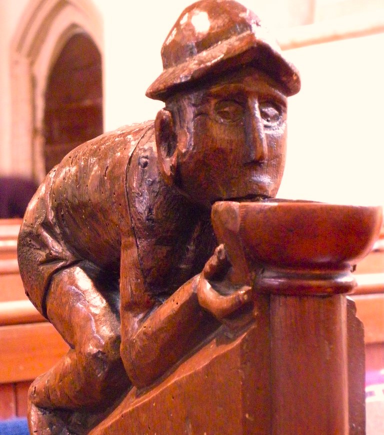 The drinking man - carved medieval bench end figure 
